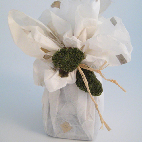 Jar wrapped in handmade paper decorated with raffia and dried moss