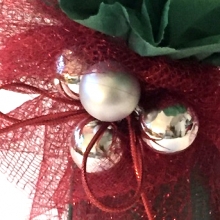 Gift wrapped in tissue paper and mesh decorated with plastic baubles and festive cord