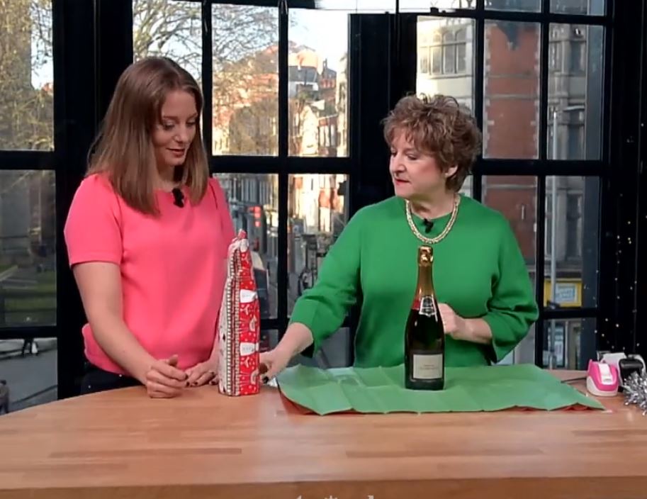 Arona showing Alex Beard how to wrap bottles on London Live TV